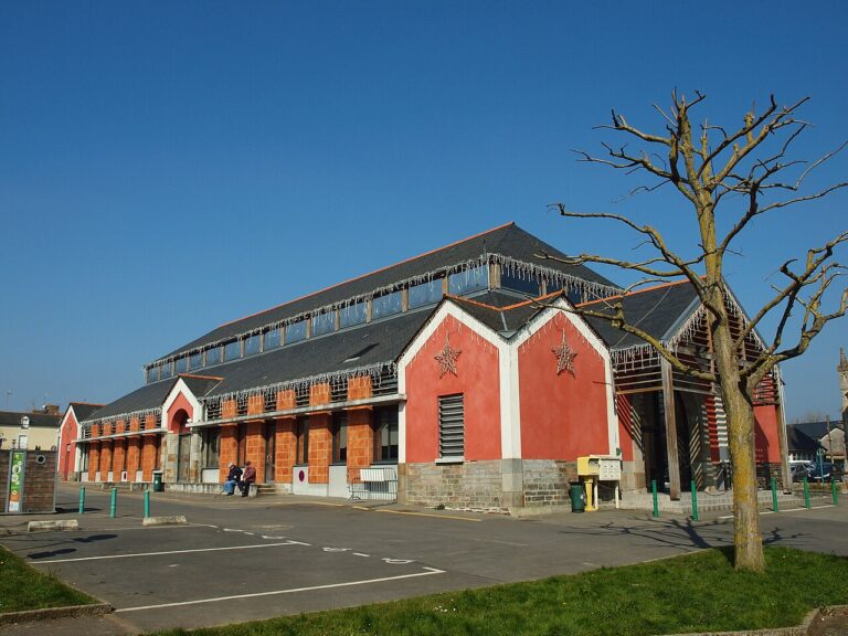 Les halles de Janzé, avec leurs façades rouges, sous un ciel bleu